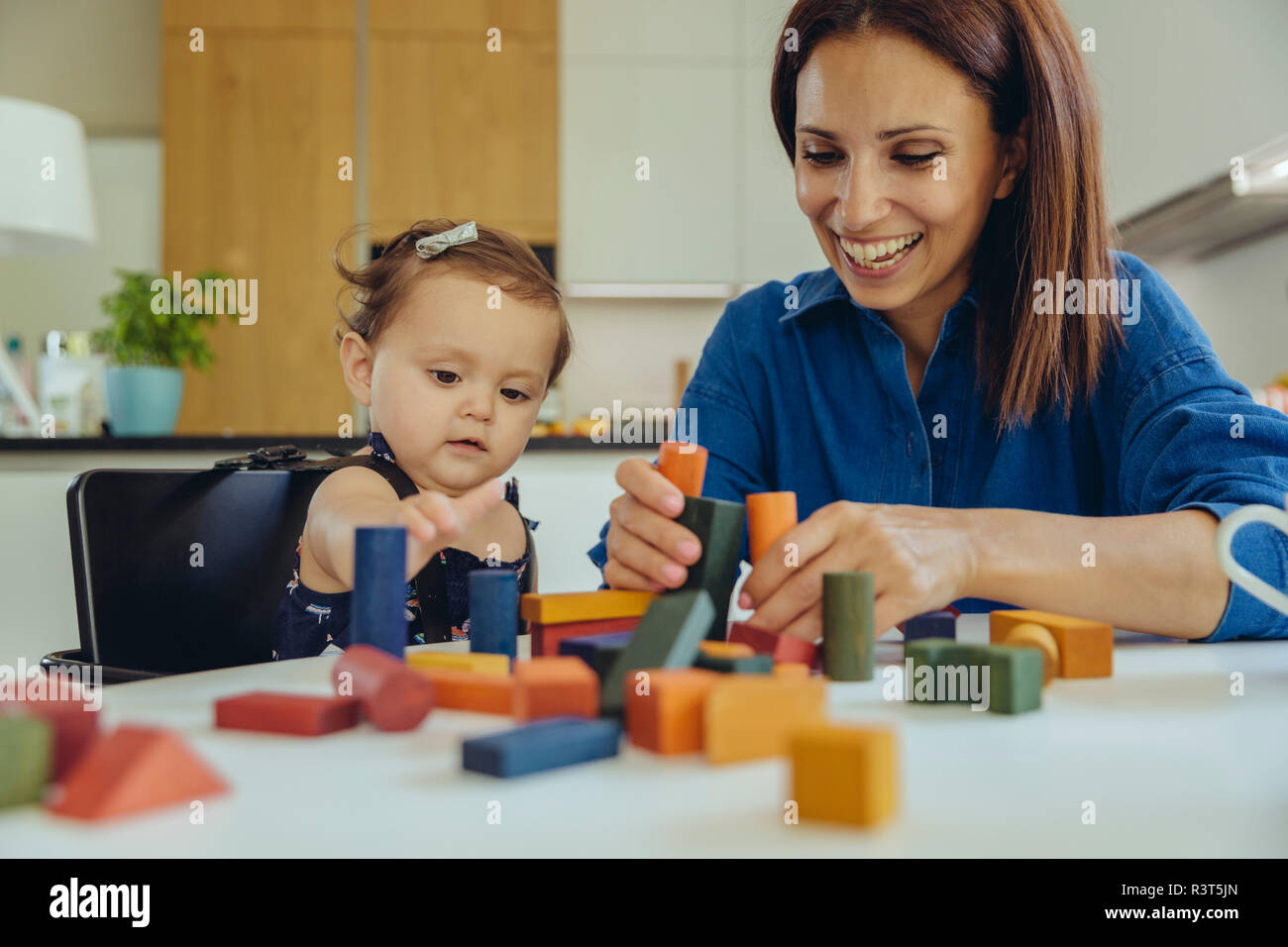 Happy mother and baby daughter playing with building blocks Stock Photo