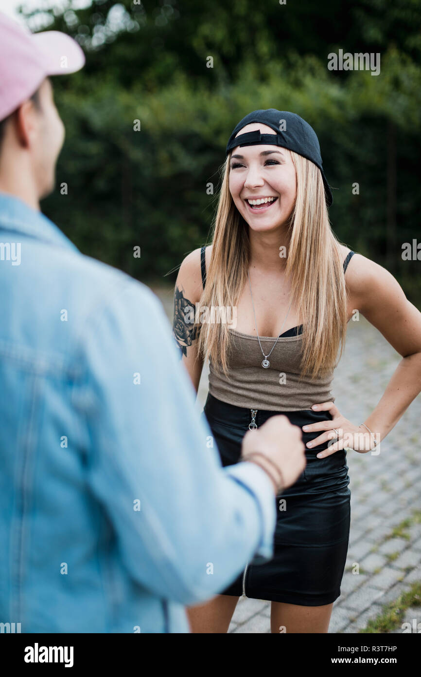 Young woman laughing at man outdoors Stock Photo - Alamy