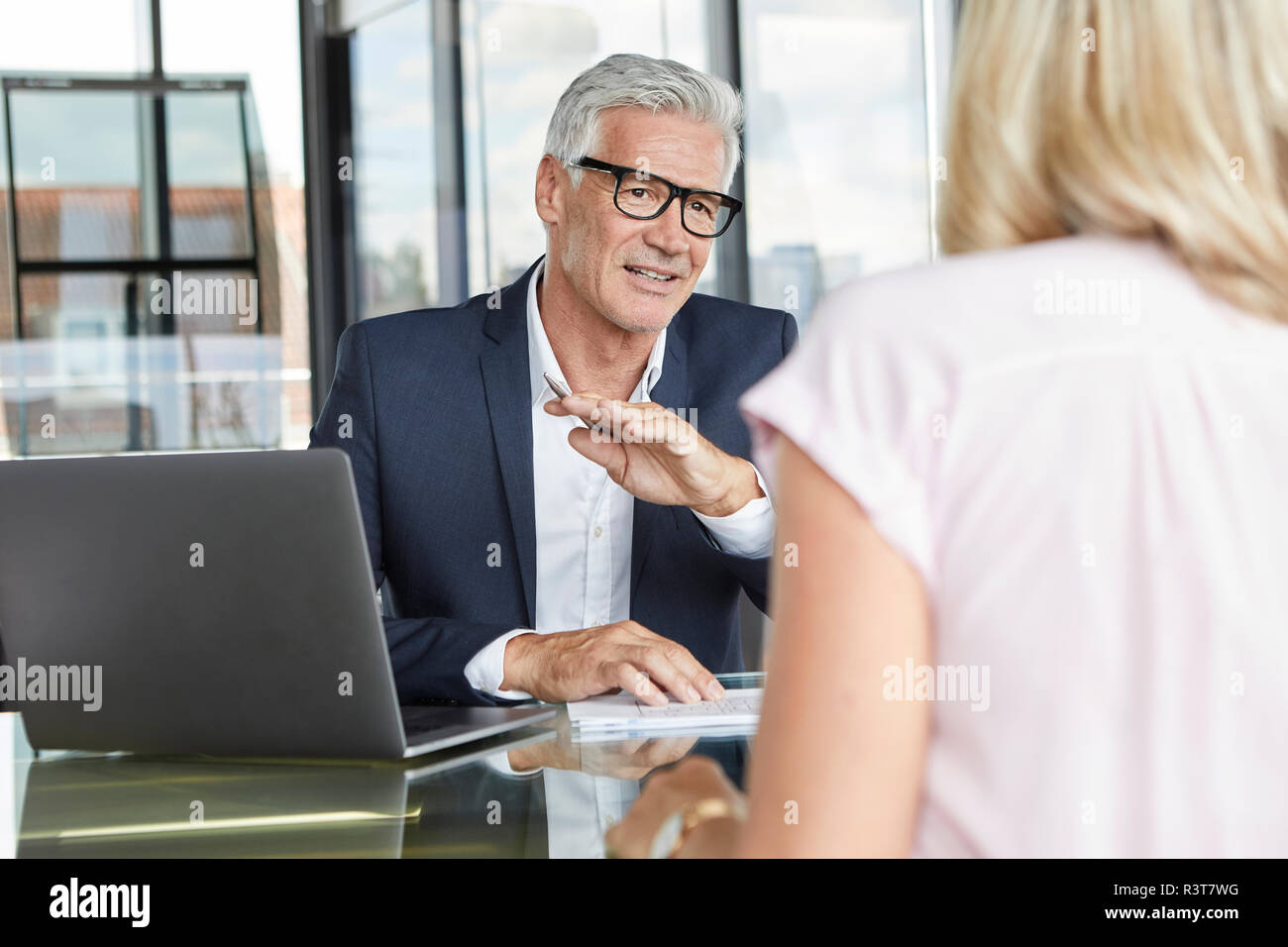 Businessman snd woman sitting in office, discussing project Stock Photo