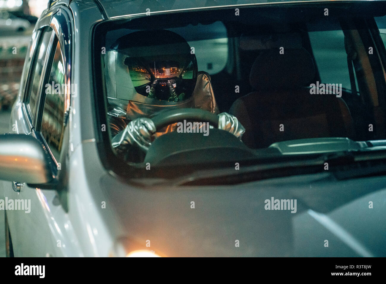 Spaceman driving car at night Stock Photo