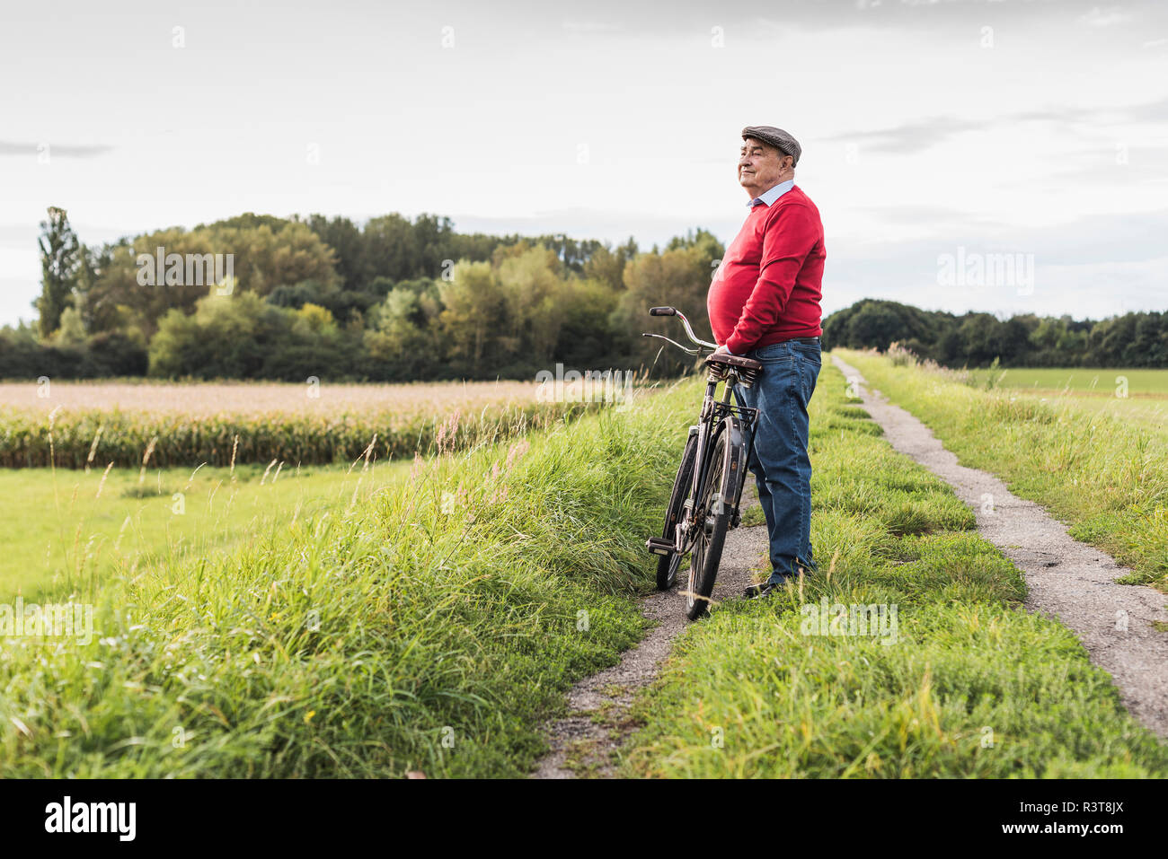 Senior man with bicycle in rural landscape Stock Photo