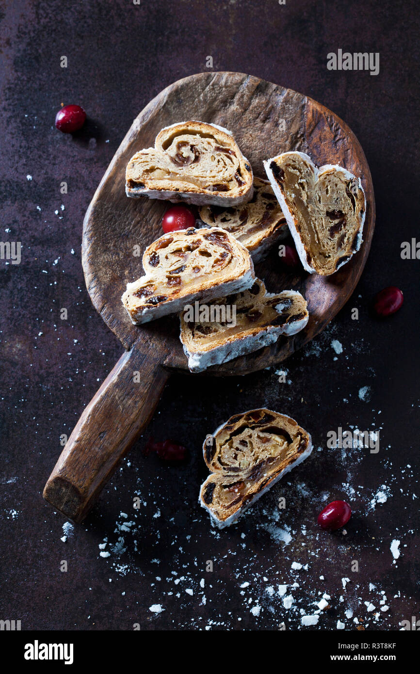 Sliced Christmas Stollen with icing sugar on a wooden scoop Stock Photo