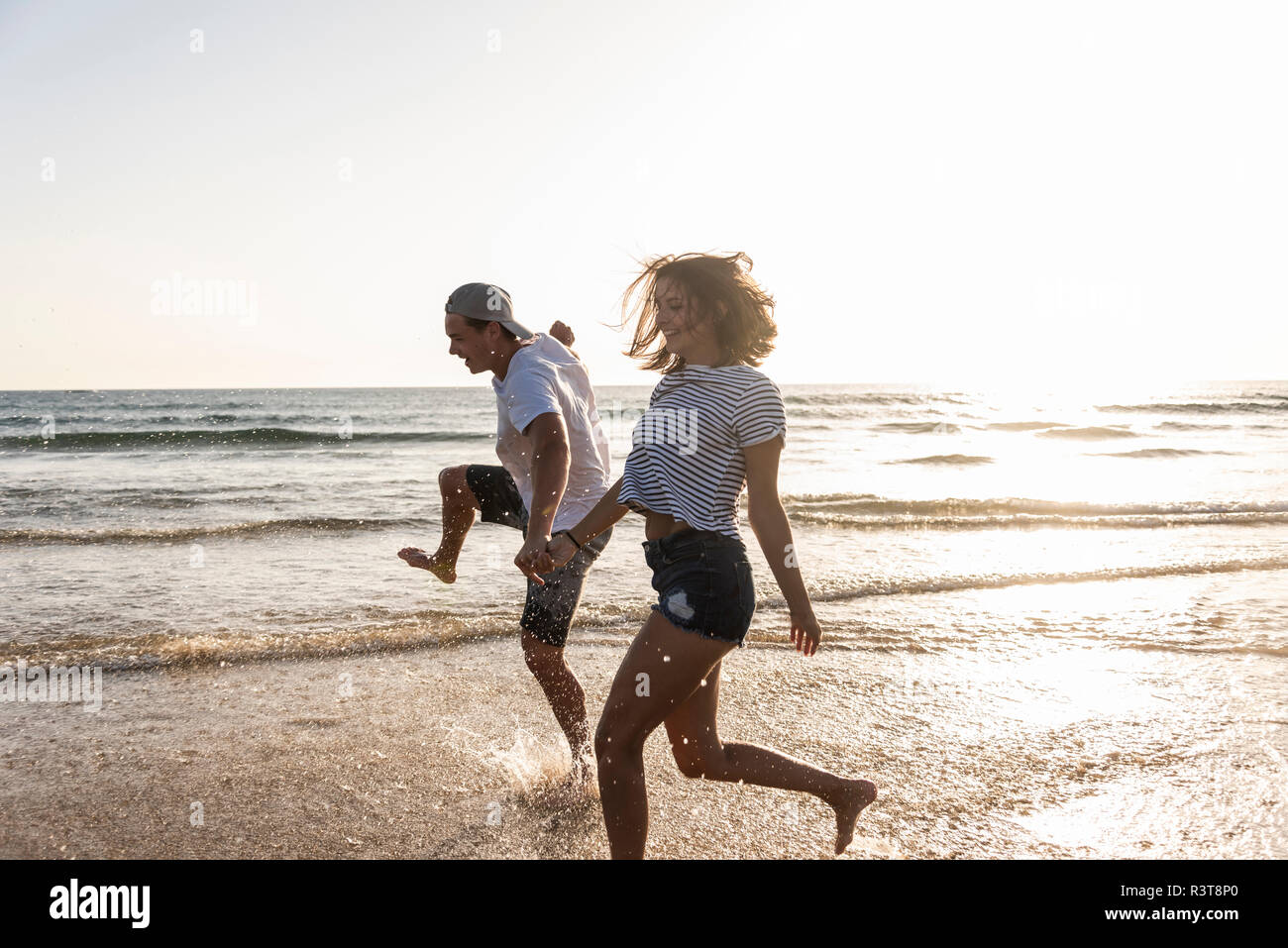 Young couple having fun at the beach, splashing water in the sea Stock ...