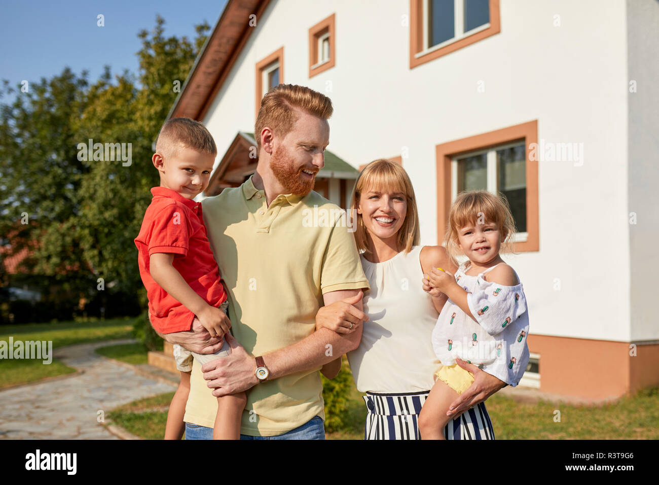 Portrait of happy family in garden of their home Stock Photo