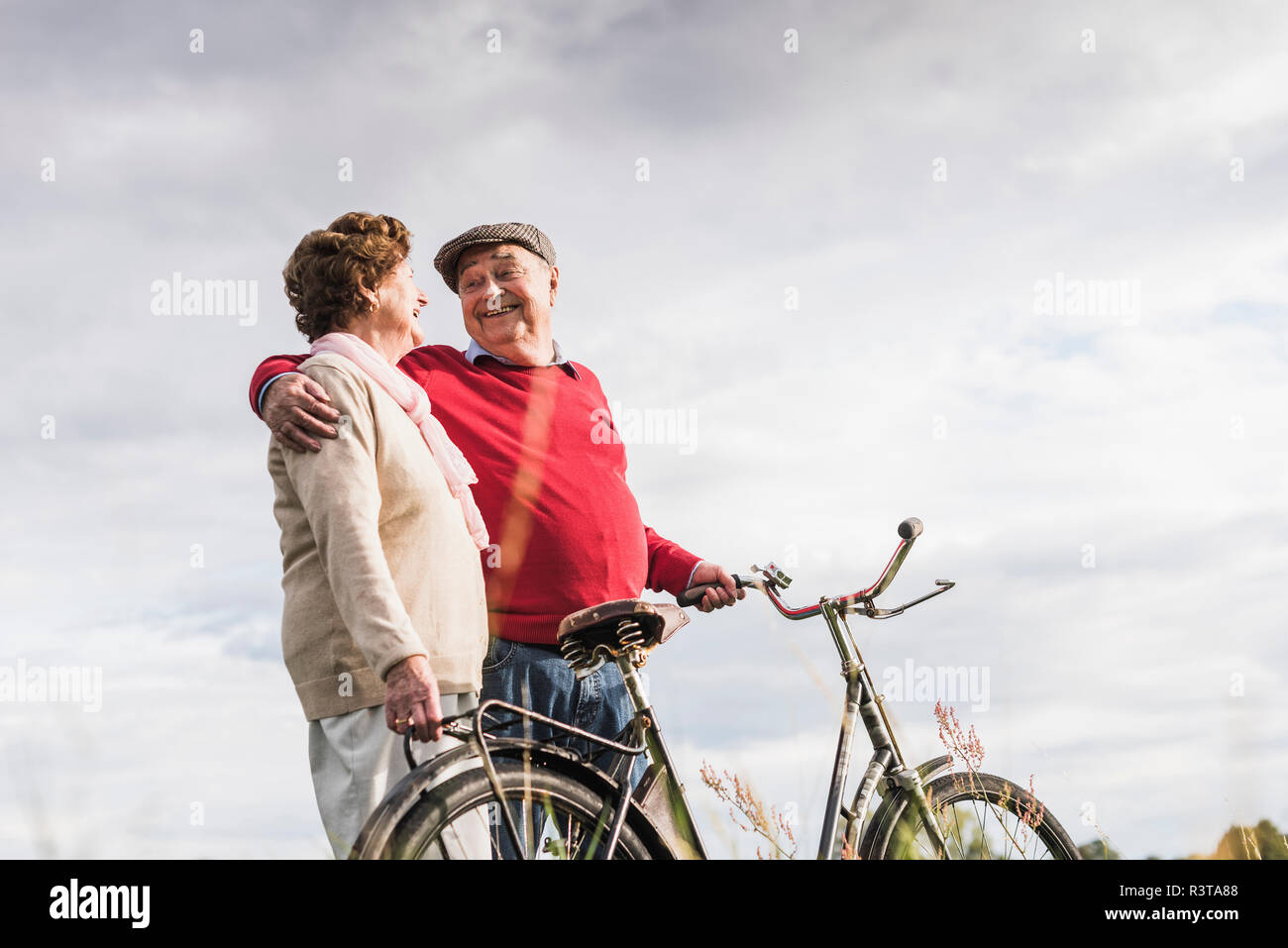 Happy senior couple with bicycles embracing Stock Photo
