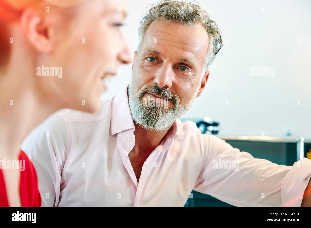 Mature man looking at female colleague in office Stock Photo