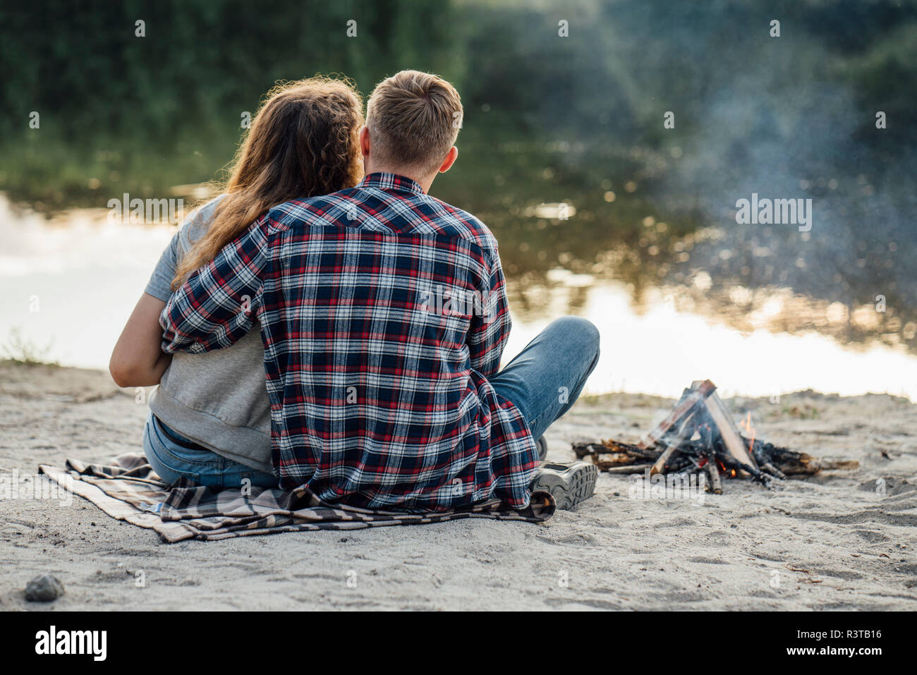 Romantic couple sitting at the riverside Stock Photo - Alamy