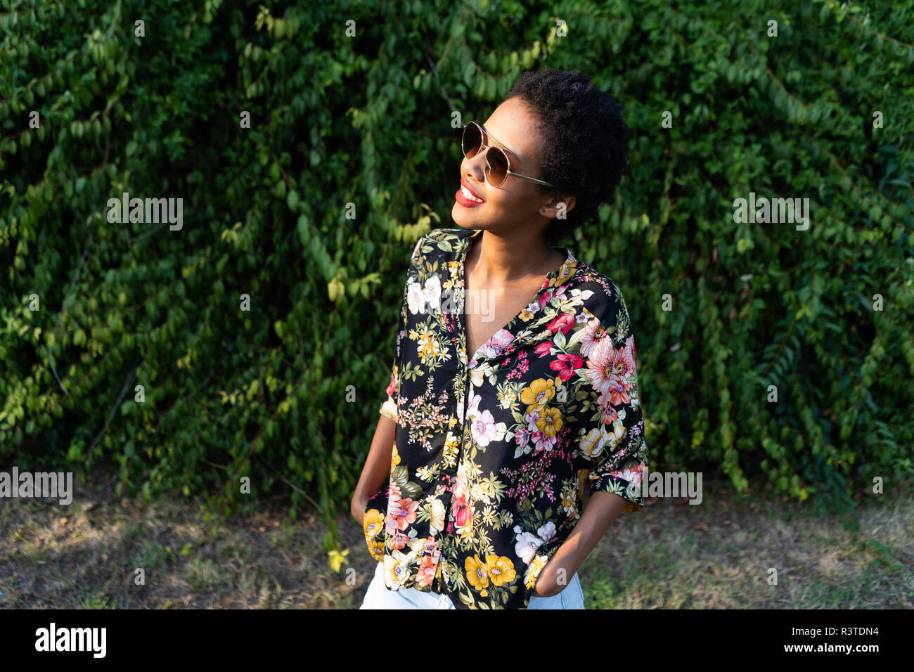 Smiling young woman wearing sunglasses and colourful blouse Stock Photo Smiling young woman wearing sunglasses and colourful blouse Stock Photo