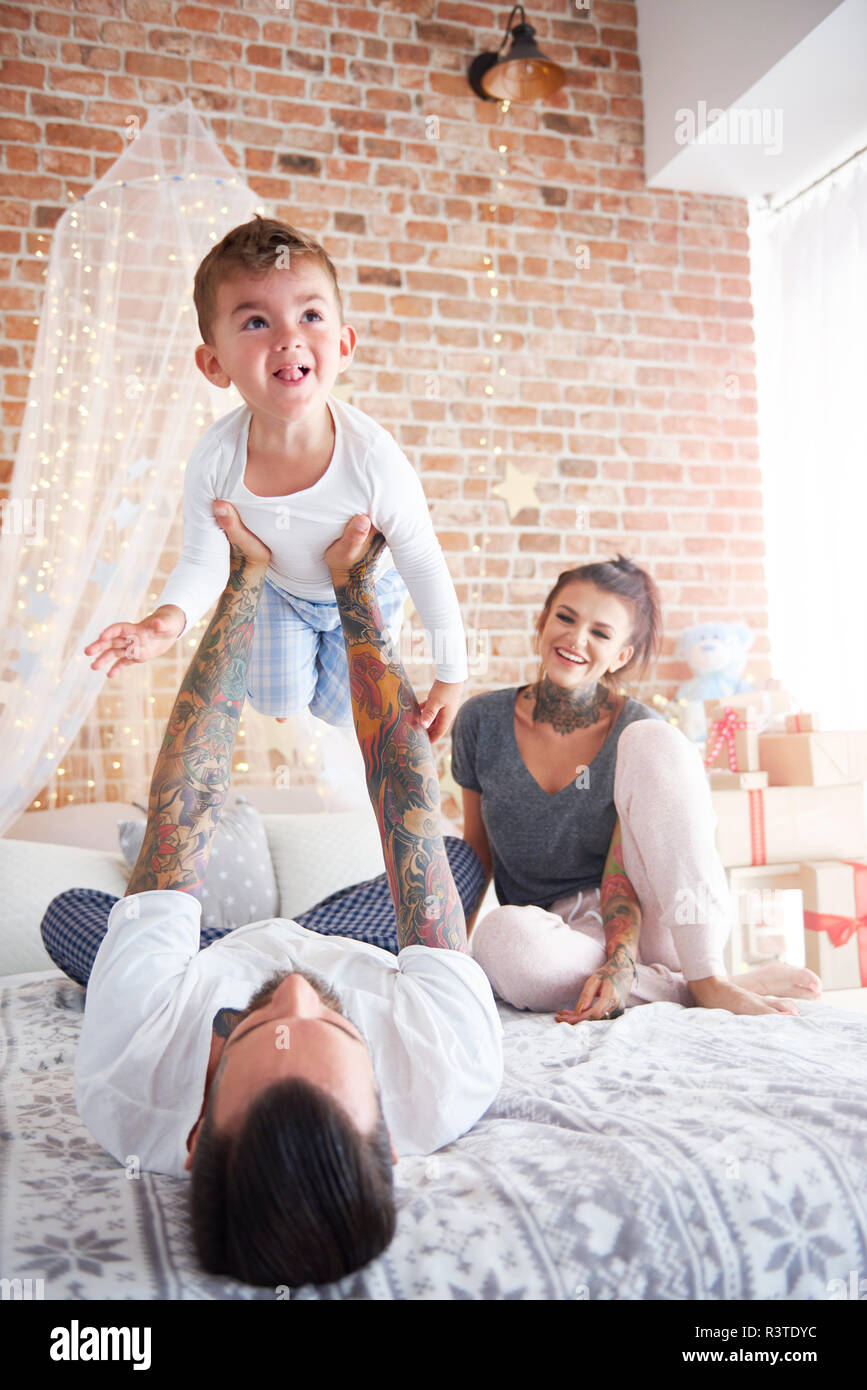 Father lifting up son at Christmas time in bed Stock Photo