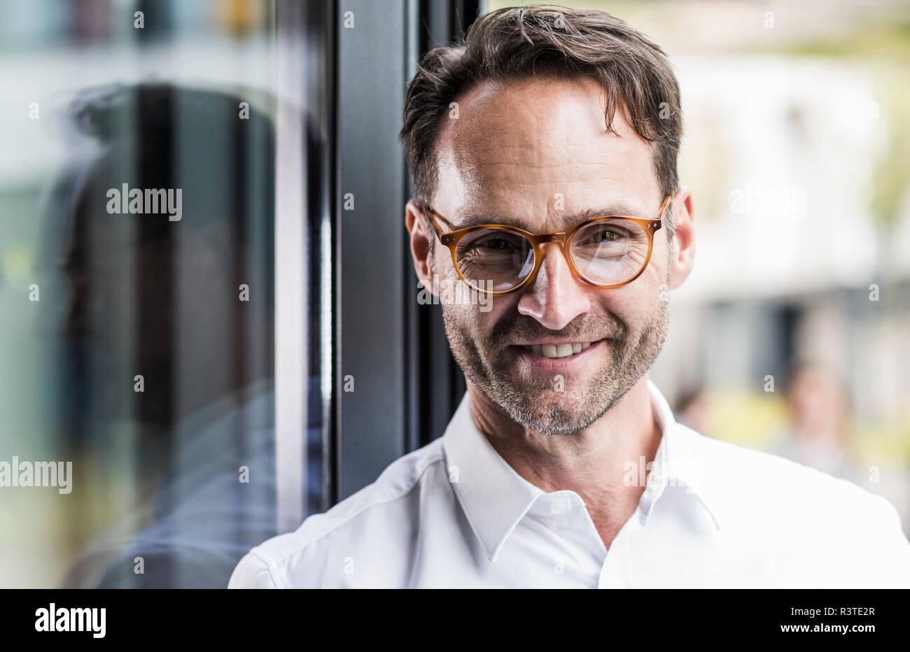 Portrait of smiling businessman wearing glasses Stock Photo
