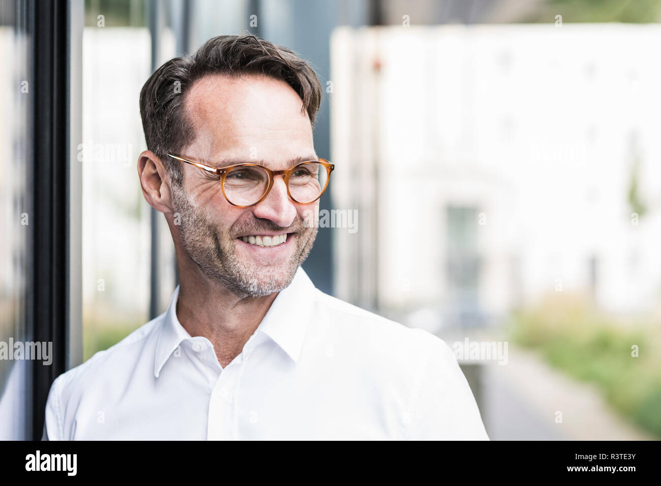 Portrait of smiling businessman with stubble wearing glasses Stock Photo