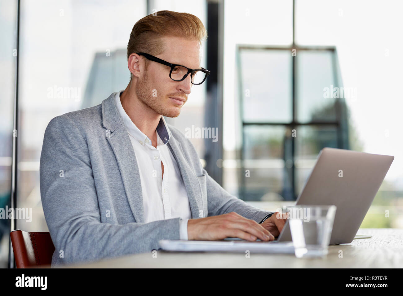 Businessman using laptop on desk in office Stock Photo