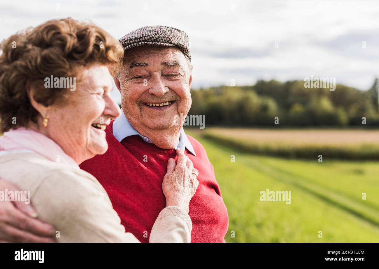 Happy senior couple embracing in rural landscape Stock Photo