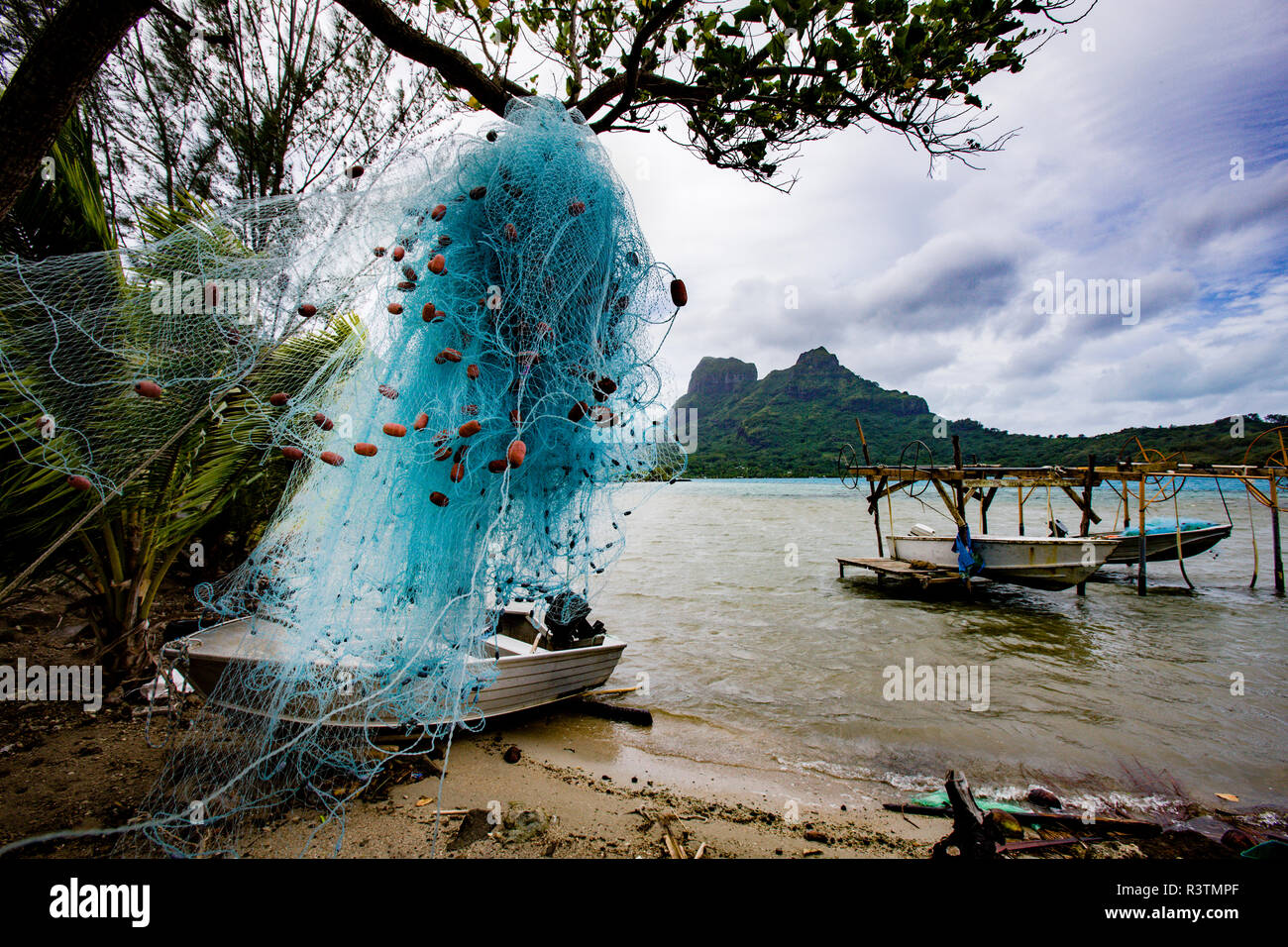 Fishing net getting dried. lagoon view with moored boats. Bora Bora