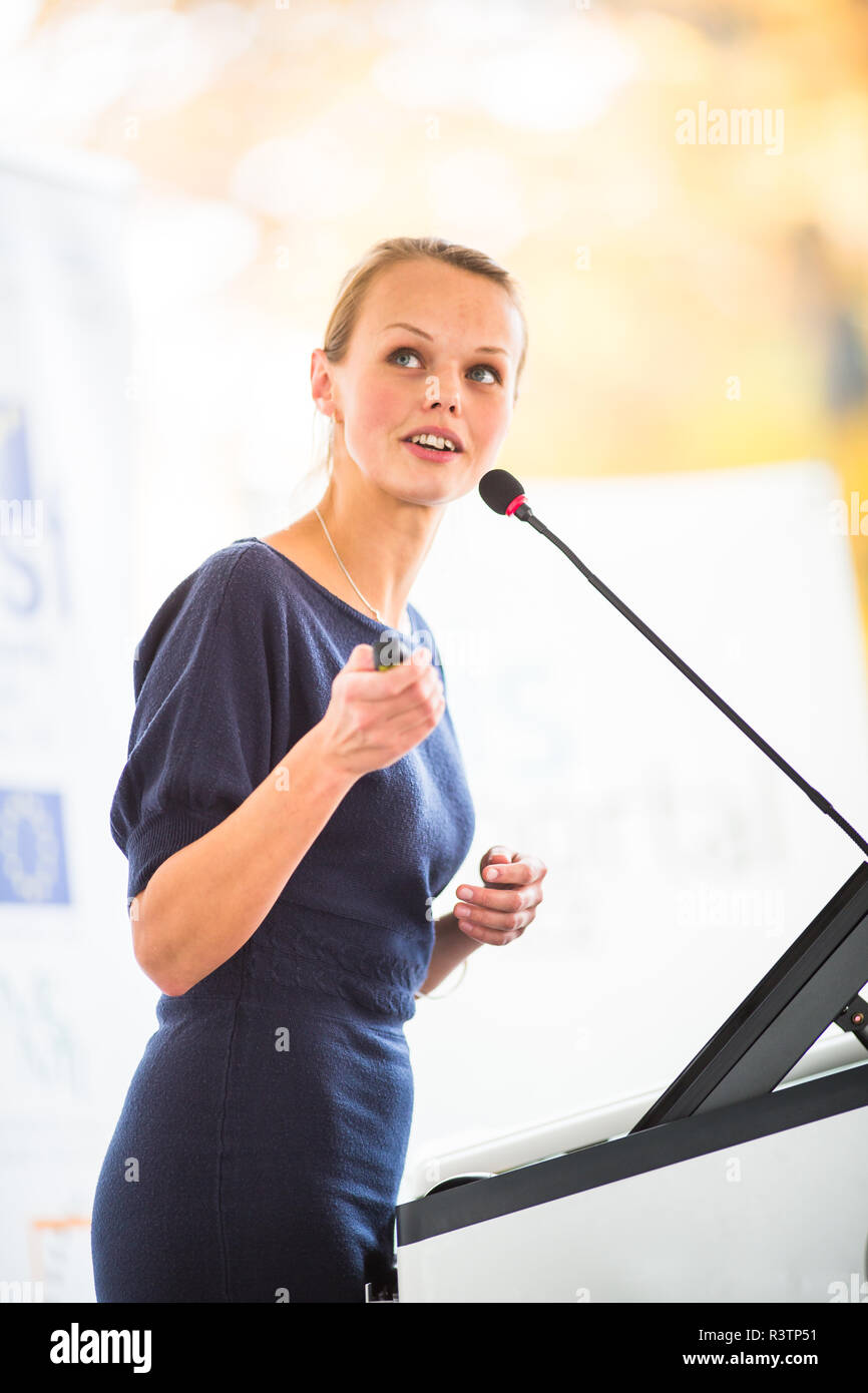 Pretty, young business woman giving a presentation in a conference ...