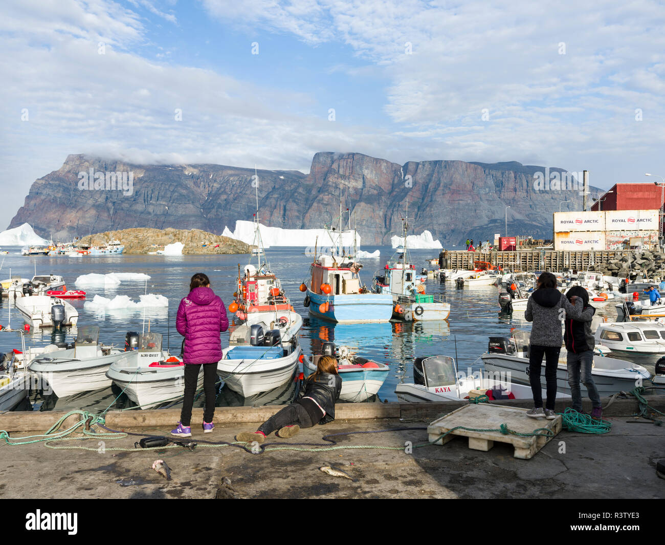 Harbor with kids fishing and typical fishing boats. Small town of Uummannaq in northwest Greenland, Denmark (Editorial Use Only) Stock Photo