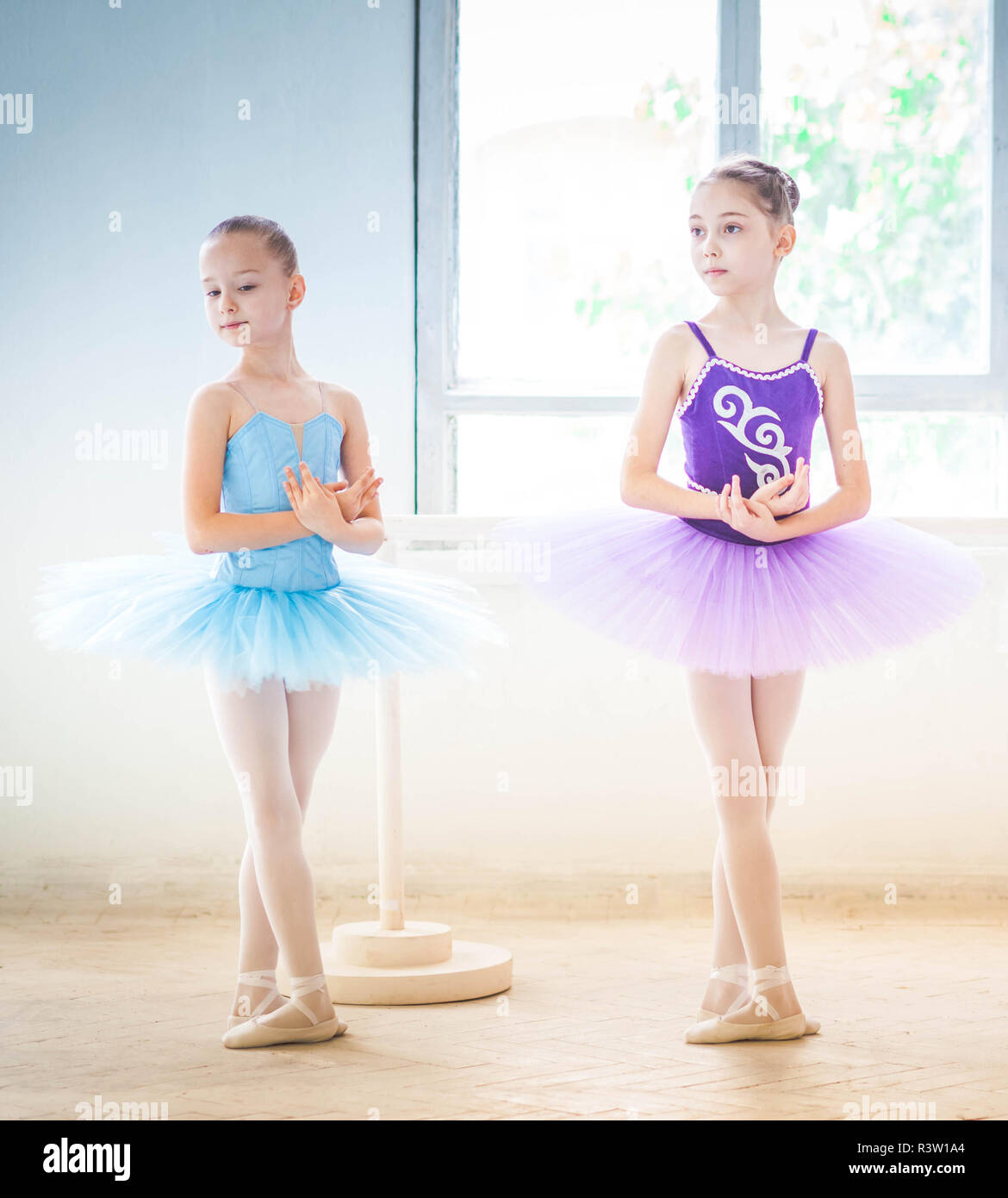 Cute little ballerina in a lilac dress and white tights in white