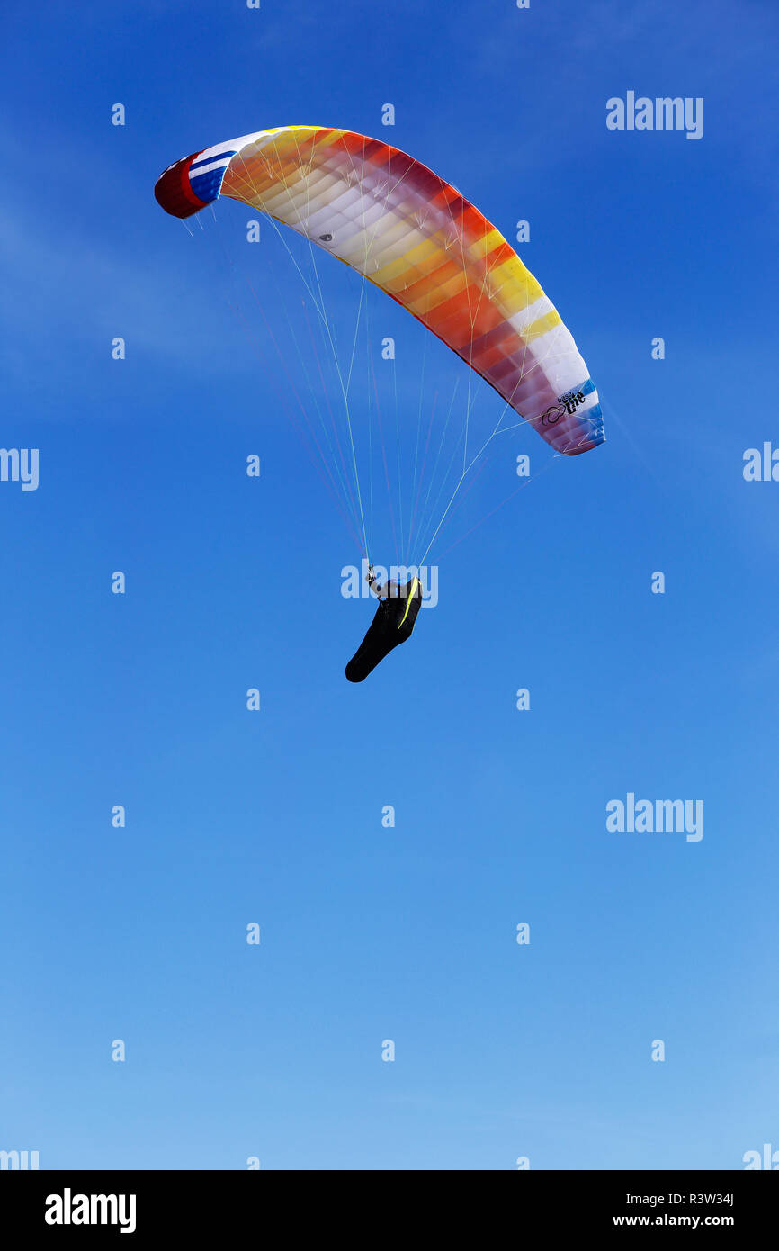 Kaseberga, Sweden - June 26, 2018: Low angel view of a paraglider against a clear blue sky. Stock Photo