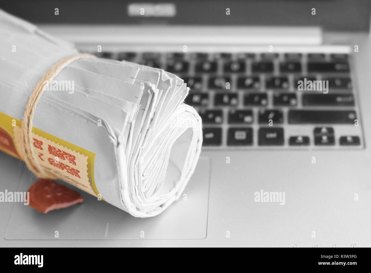 Newspapers and computer. Folded and rolled papers and magazines on keyboard of open laptop. Concept for news by different sources of information Stock Photo