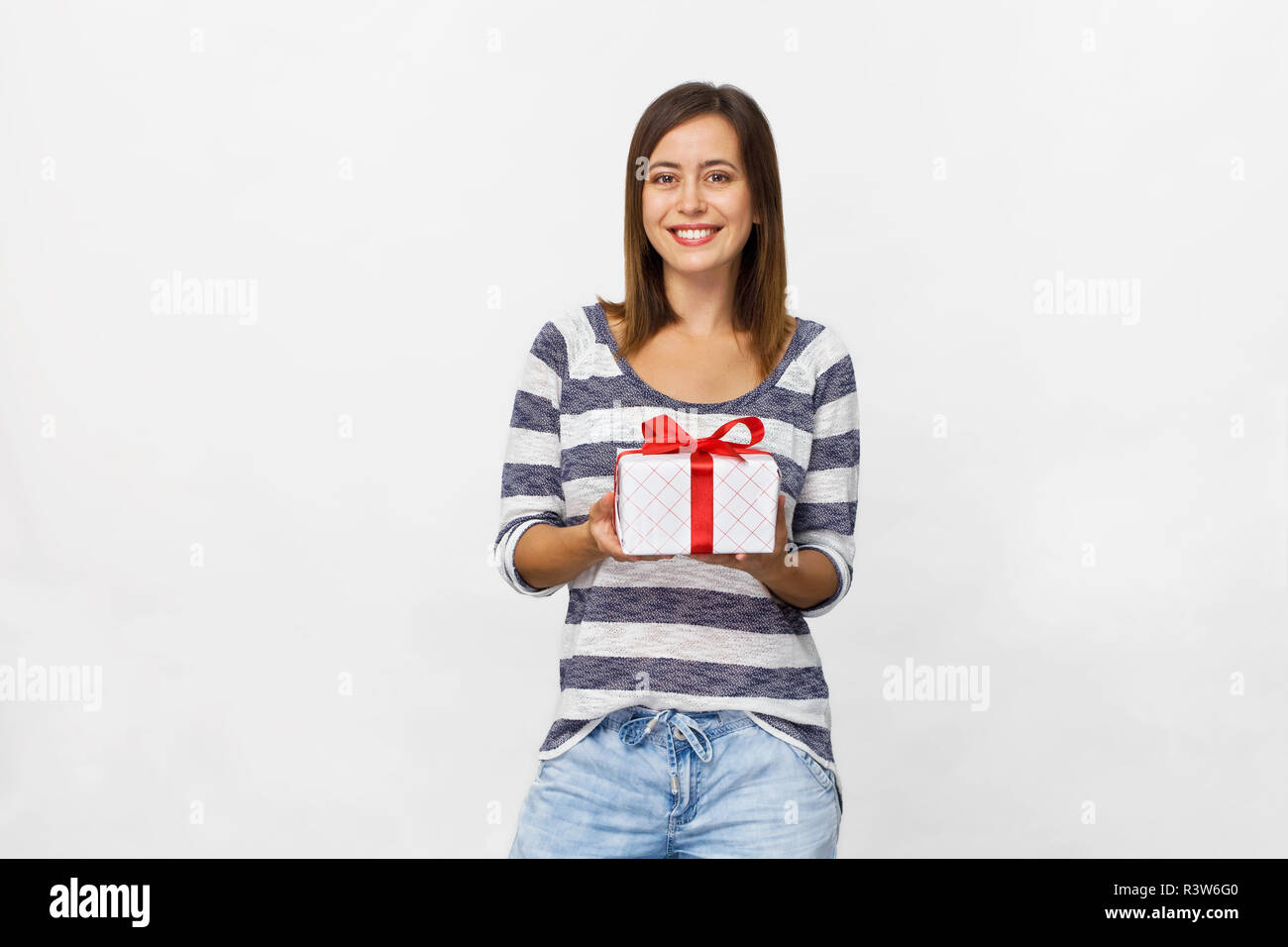 Young beautiful woman with smile holding a present. White background Stock Photo