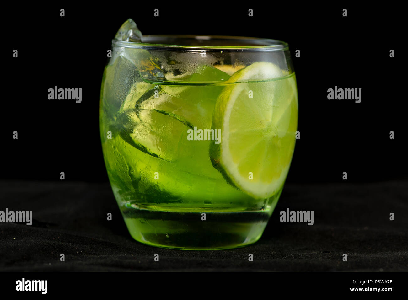 Green cocktail with gin, bitter lemon, basil and lemon with isolated black background Stock