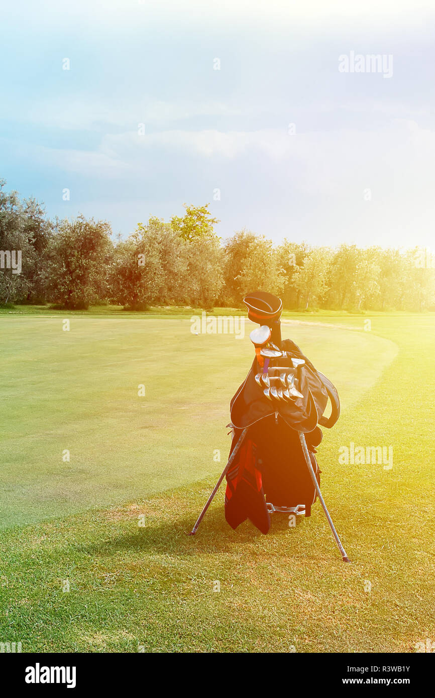 Golf club hitting golf ball along fairway towards green. Chipping a