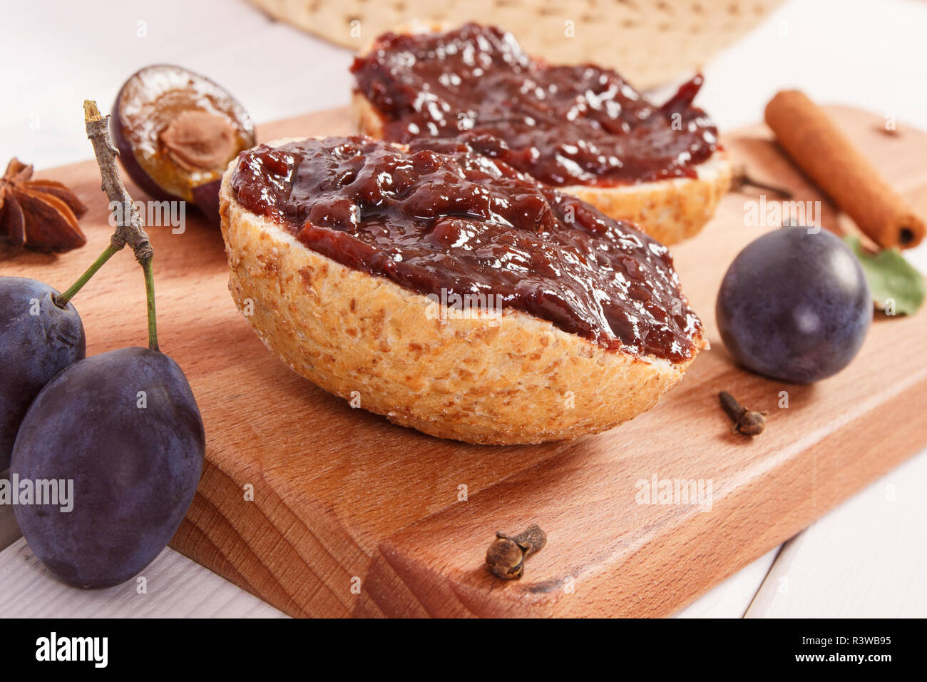 Fresh prepared sandwiches with plum marmalade or jam on wooden cutting board, concept of delicious breakfast Stock Photo