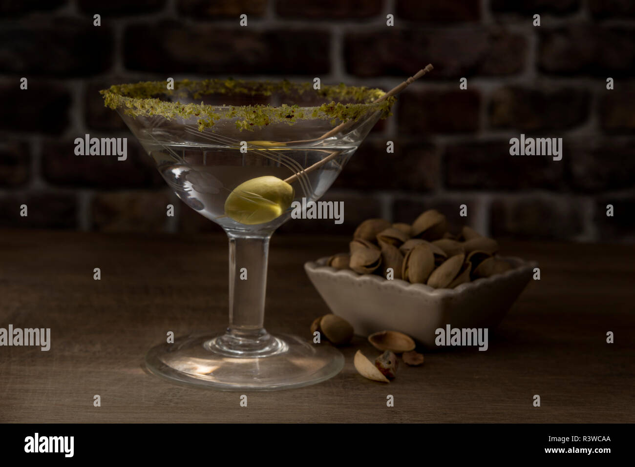 Dry Martini with green olive and pistachio Stock Photo