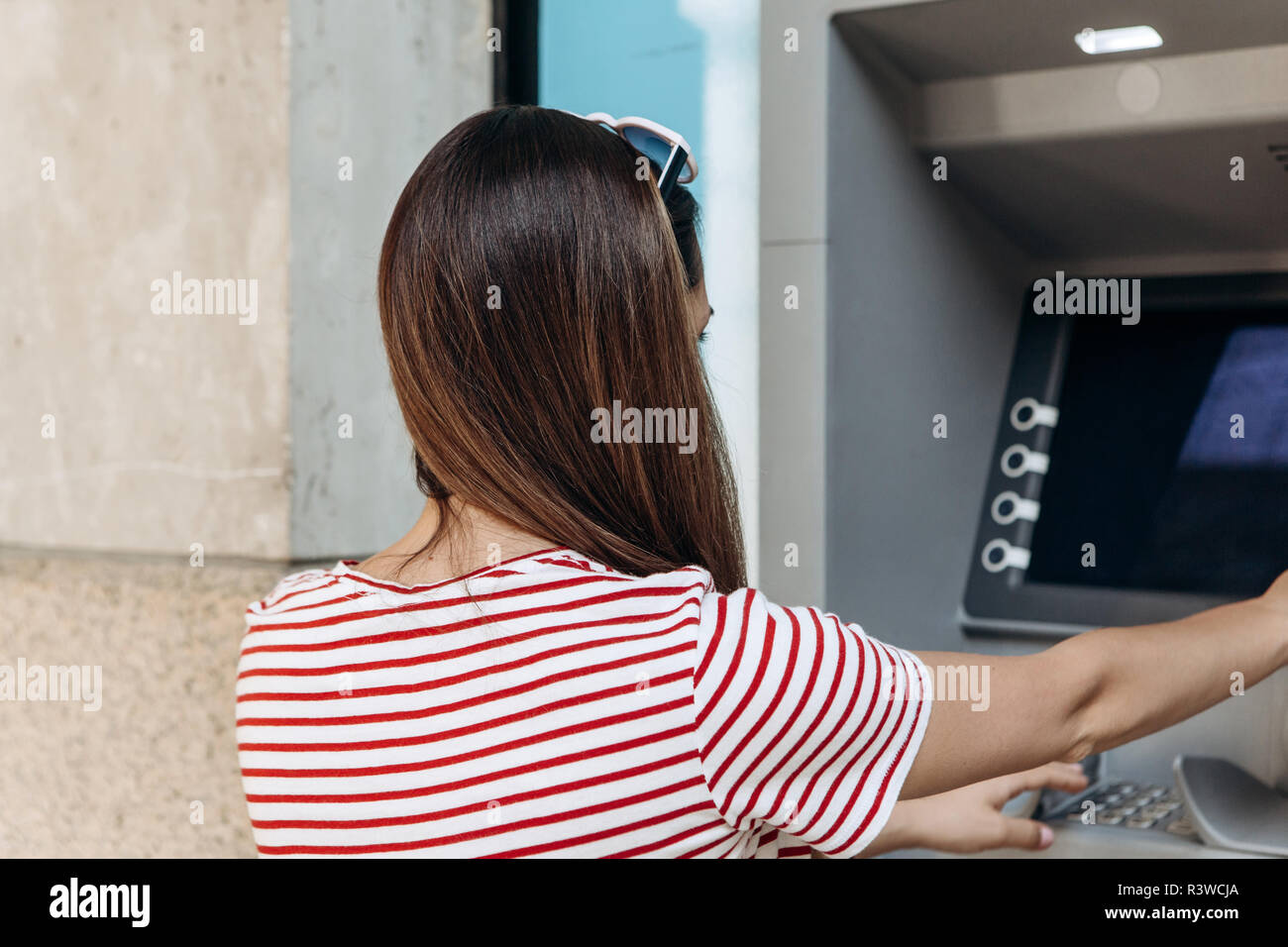 The tourist withdraws money from the ATM for further travel. Finance, credit card, withdrawal of money. Life style. Journey. Vacation. Grabs a card from the ATM. Stock Photo