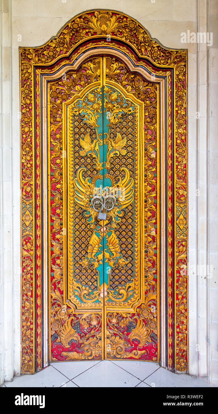 Indonesian door with carvings and painted multiple colors. Entrance to a temple and a home. Most homes in Bali are also temples. Stock Photo