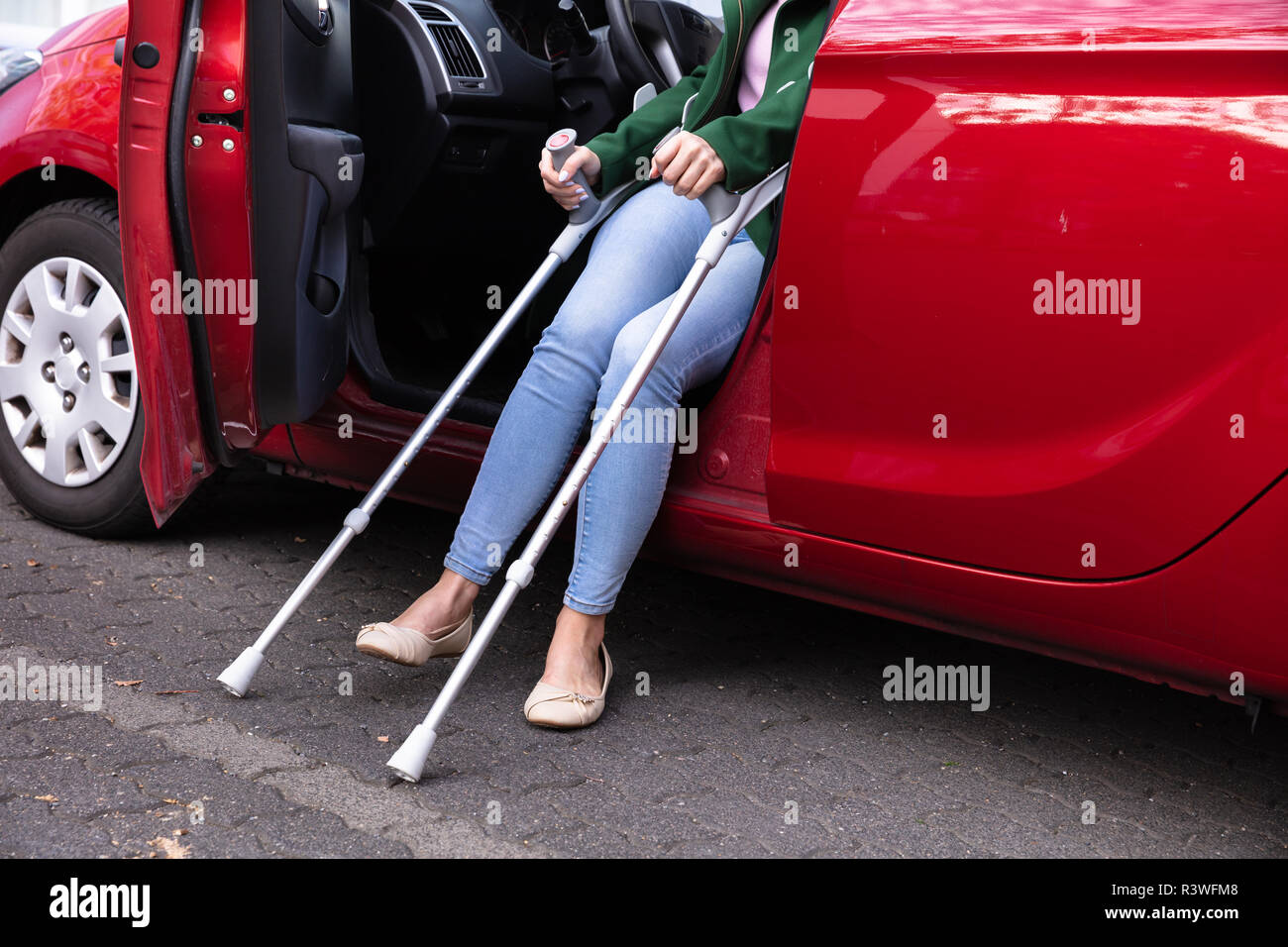 Disabled Woman With Crutches Coming Out Of A Red Car Stock Photo Alamy