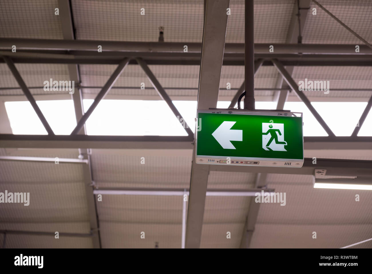 Fire exit light sign. Green emergency exit sign showing the way to