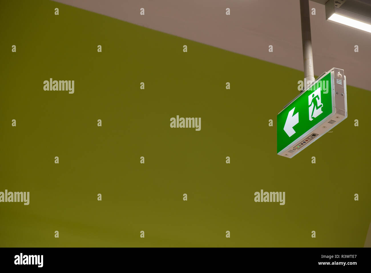 Fire exit light sign. Green emergency exit sign showing the way to