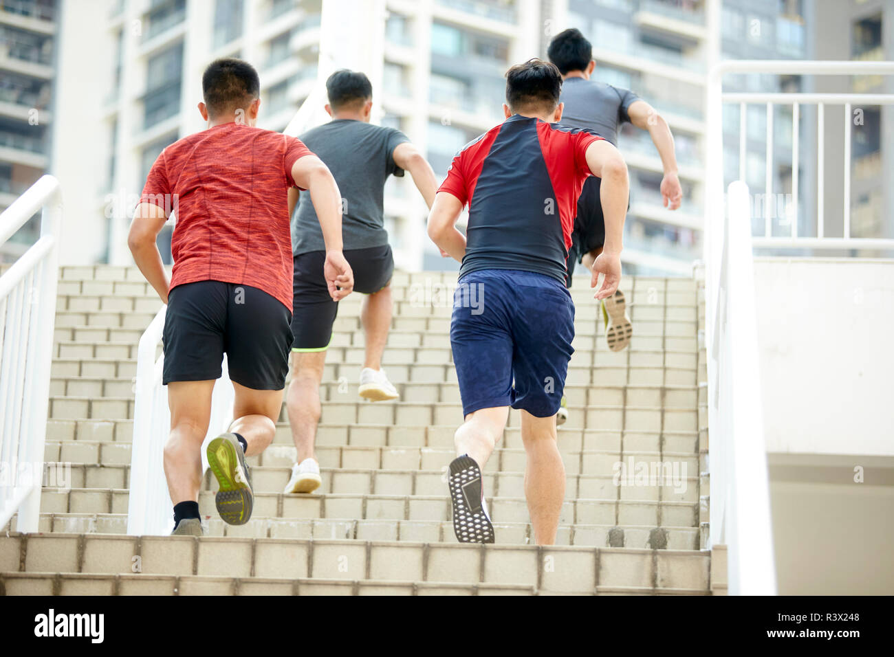 young asian male athletes exercising running up the steps Stock Photo