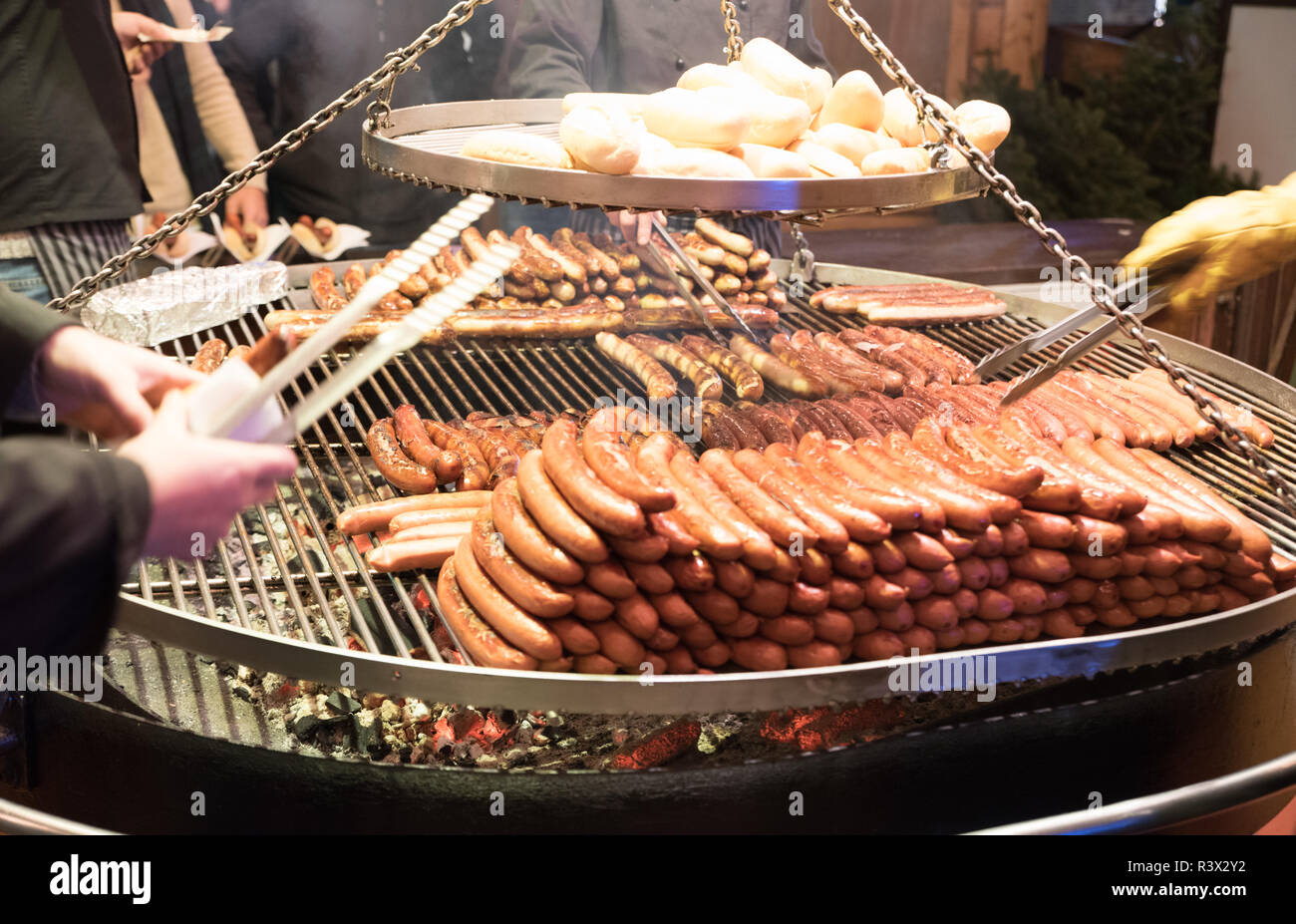 Grilling sausages on barbecue grill at a food stall of Christmas market