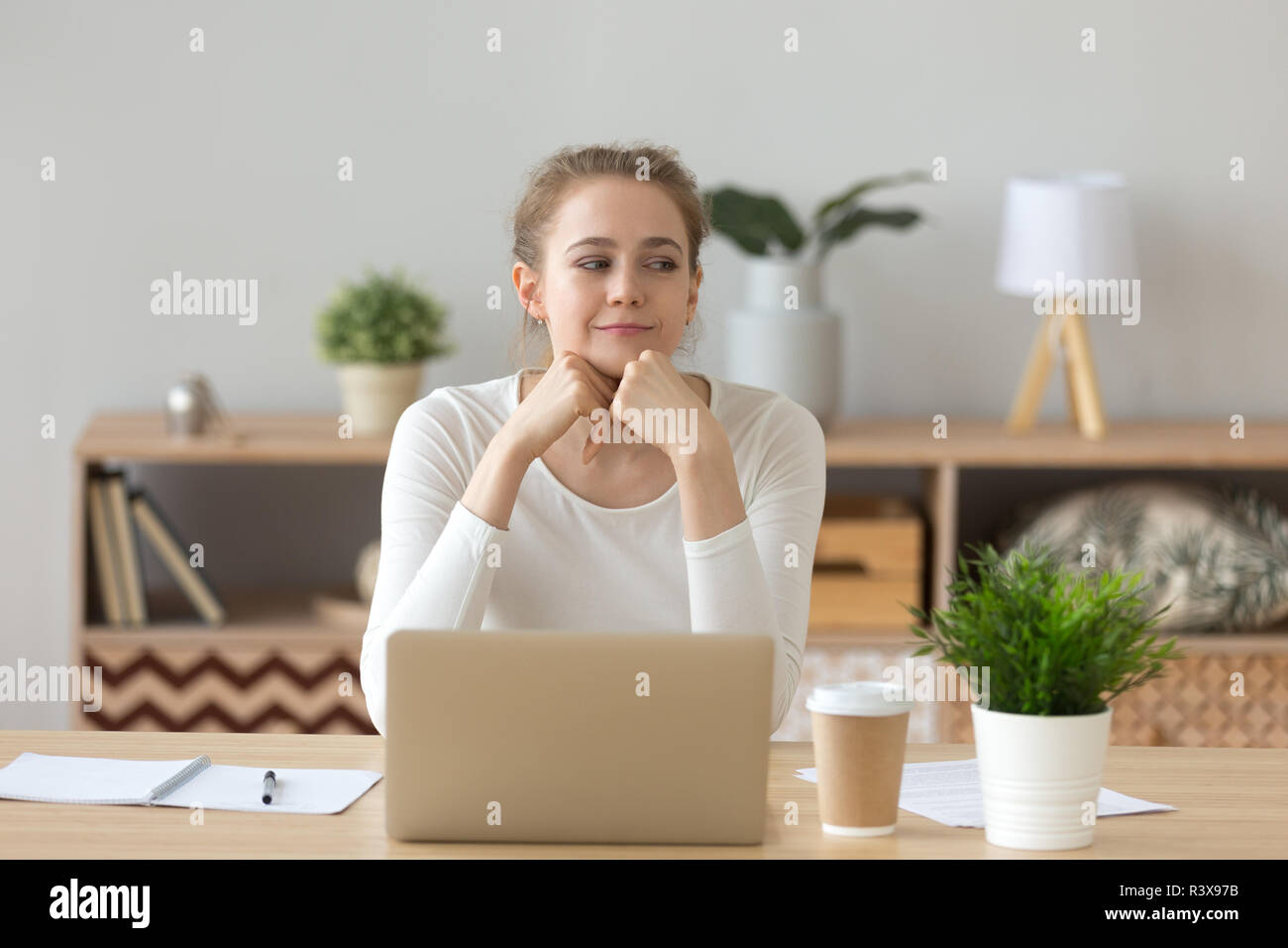 Dreamy girl looking aside thinking of future success Stock Photo