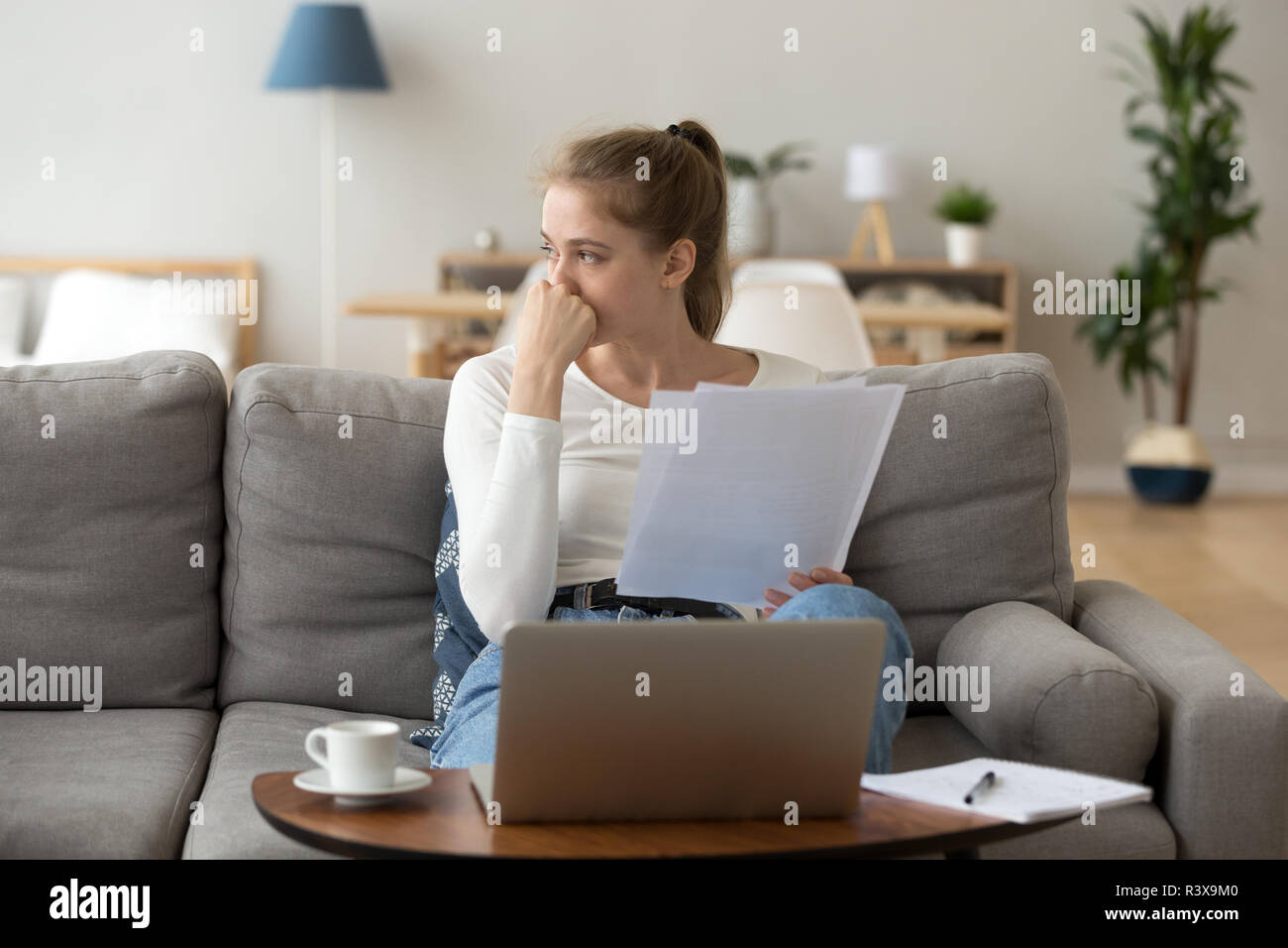 Thoughtful young female distracted from studying looking away Stock Photo