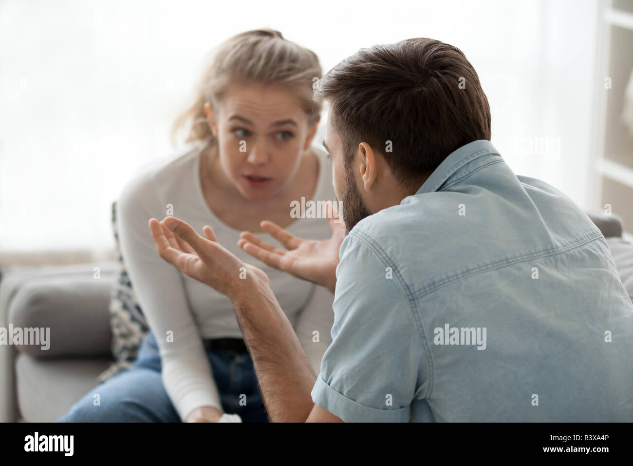 Mad millennial husband and wife arguing at home  Stock Photo