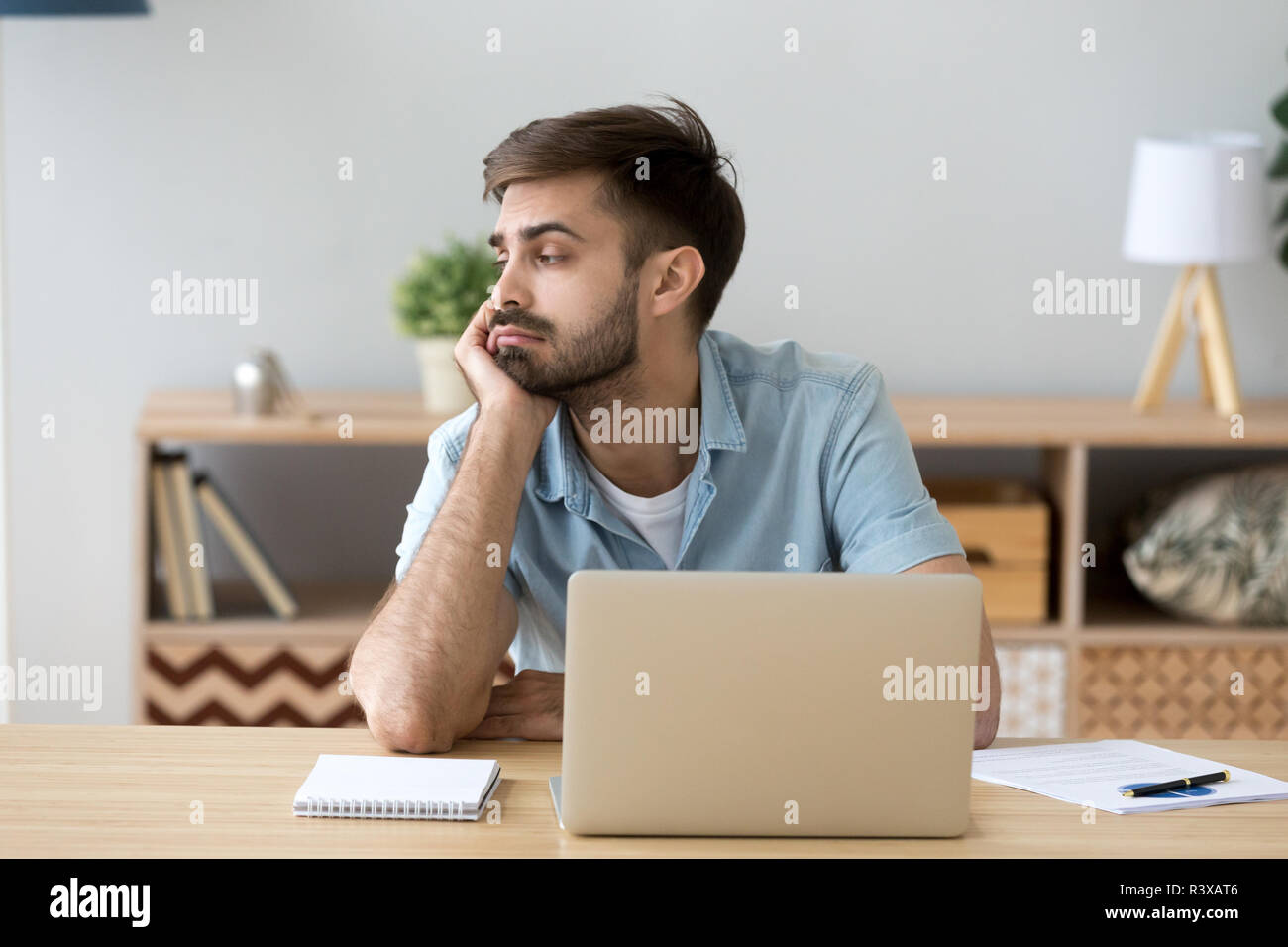 Tired man distracted from computer work lacking motivation Stock Photo