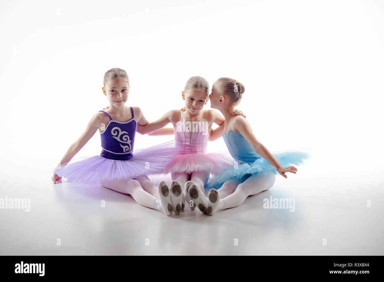 Three little ballet girls sitting in tutu and posing together Stock ...
