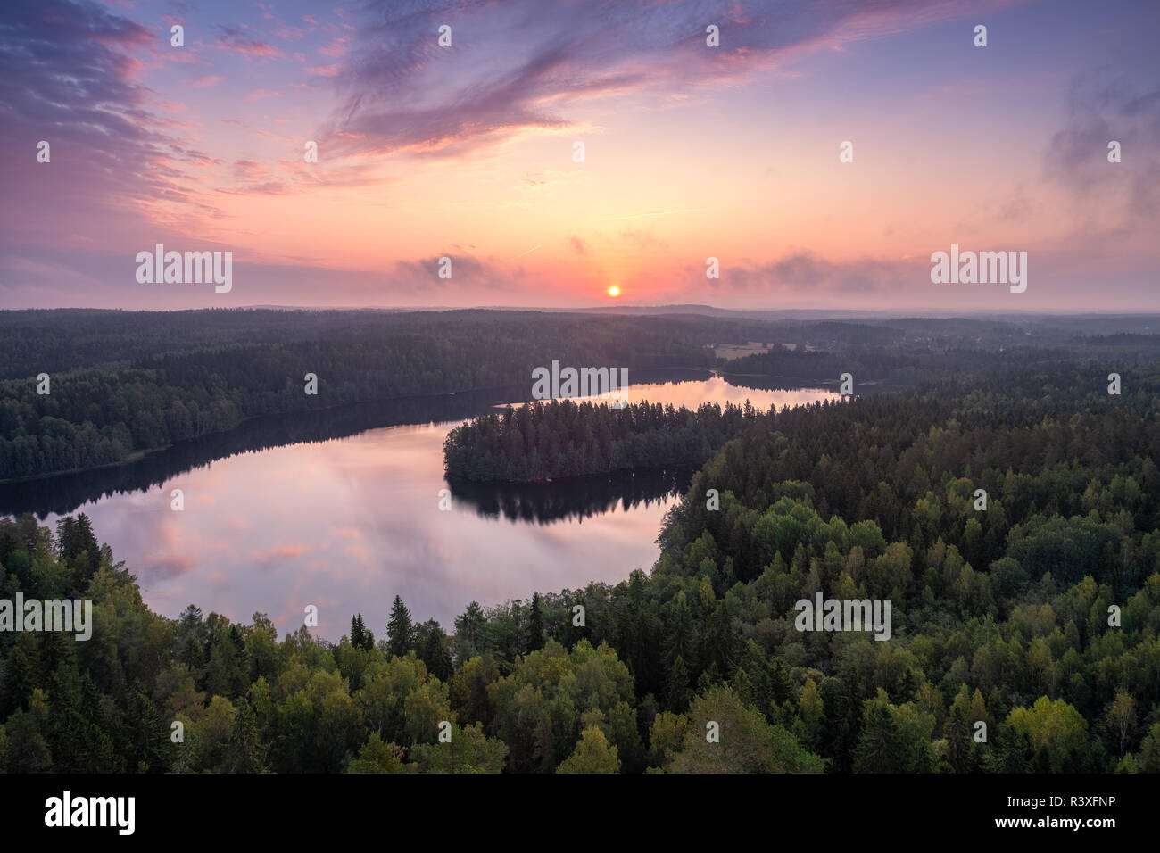Scenic high angle landscape with sunrise, forest and lake at autumn morning in nature reserve, Finland Stock Photo