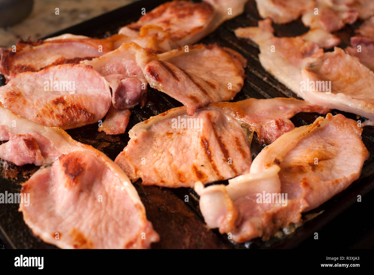 Cooking rashers of bacon for breakfast Stock Photo Alamy