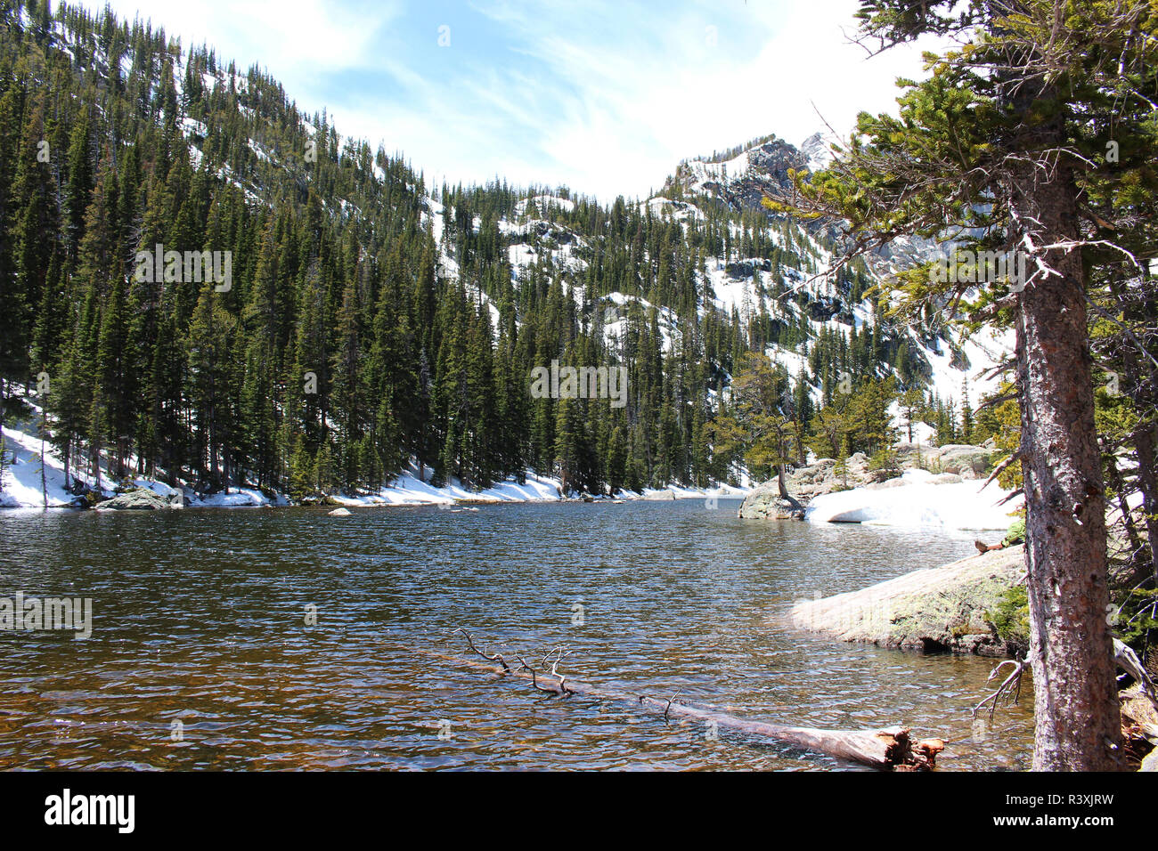 A view across Emerald Lake including snow capped mountain peaks and a ...