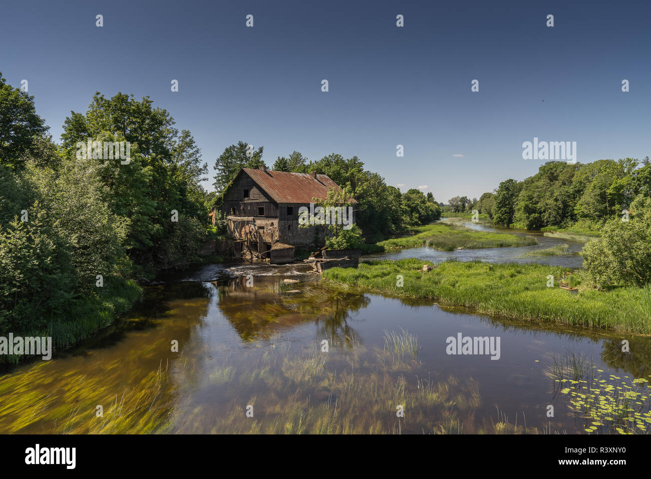 Ancient abandoned water mill surrounded by beautiful nature. House built of stone and wood, walls and bridge on is reflecti Stock Photo - Alamy
