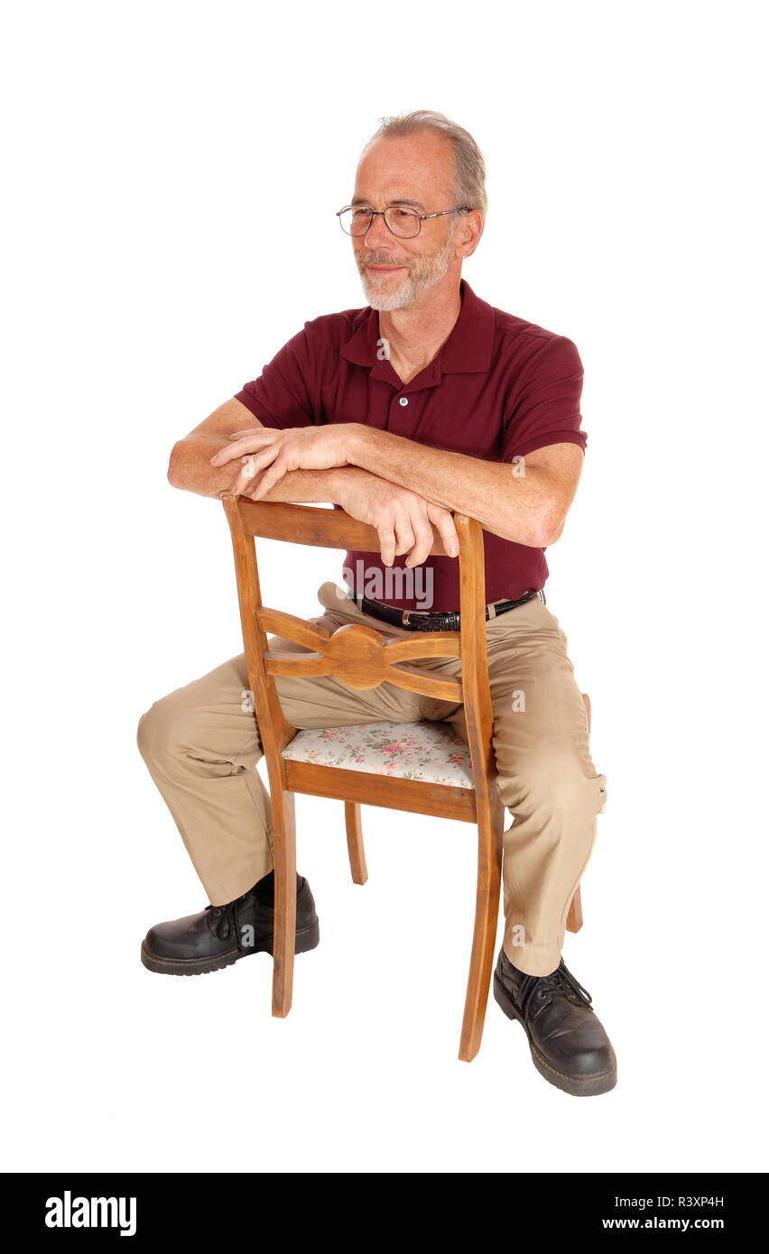 Middle age man sitting backwards on chair Stock Photo Alamy