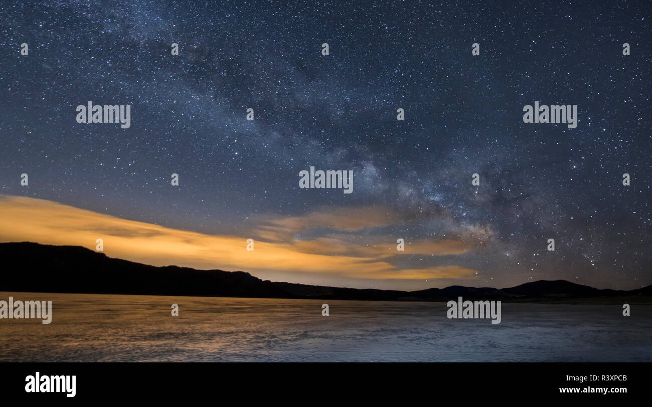 USA, Colorado, Front Range. Milky Way and frozen lake at sunrise. Stock Photo