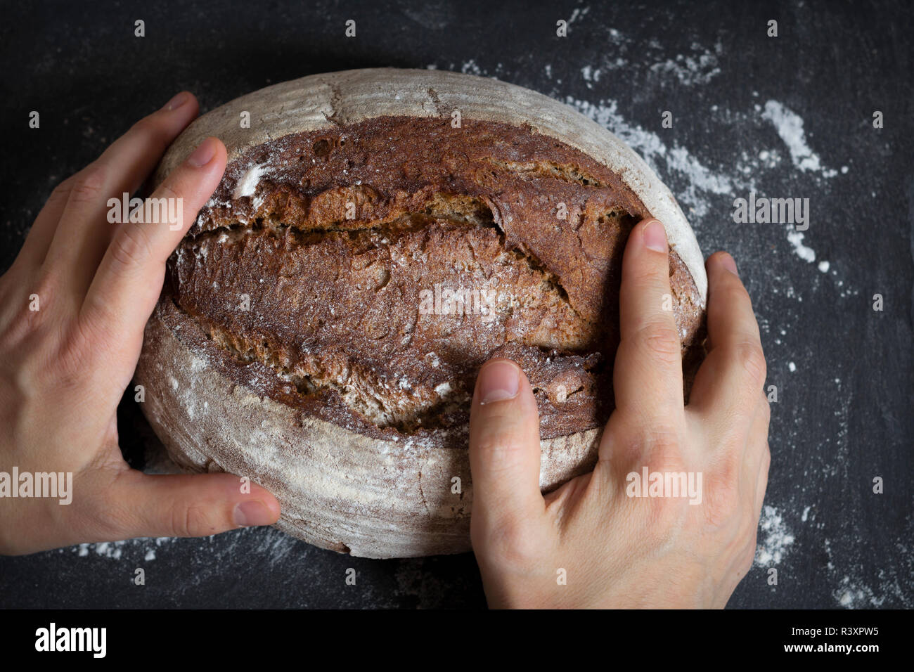 male hands holding bread loaf Stock Photo