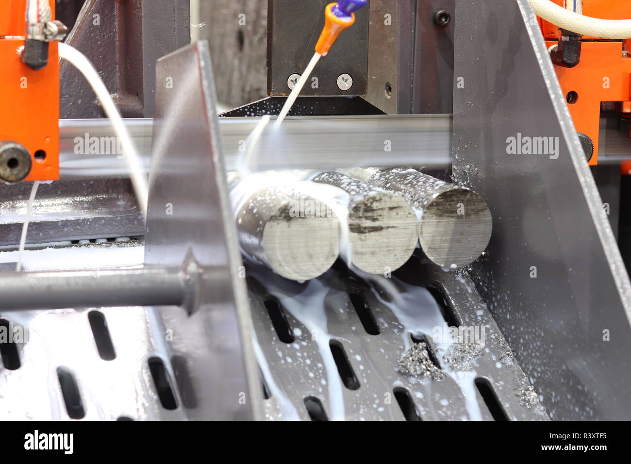Steel bar cutting by band saw machine with coolant Stock Photo Alamy
