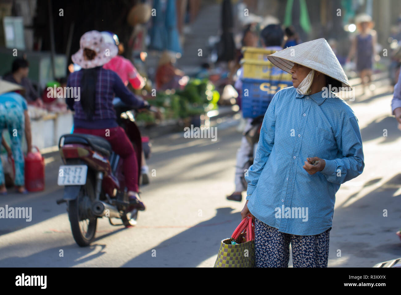vietnamese woman in conical hat walking down the street, Hoi An, Vietnam. Stock Photo