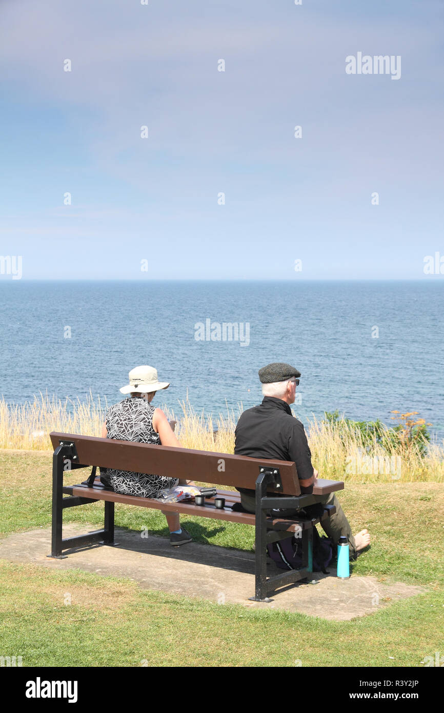 Elderly Couple On Park Bench Looking Out To Sea Dunbar Scotland